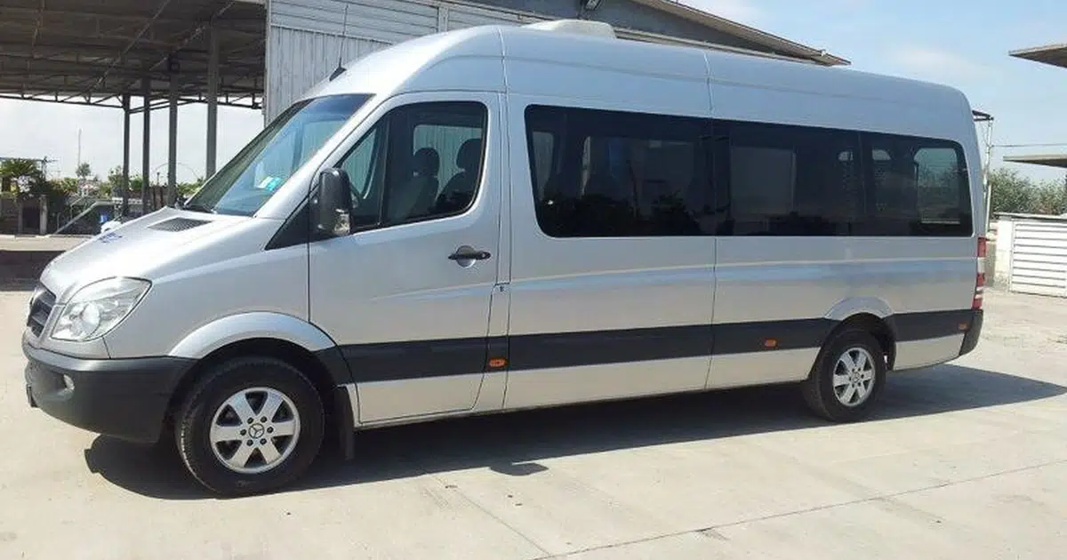 A 15 seater minibus with driver parked in Rome
