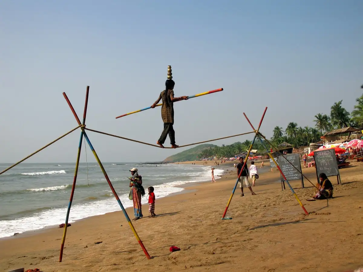 Locals perform tricks to get money of tourists on the beach Beach performers in Goa