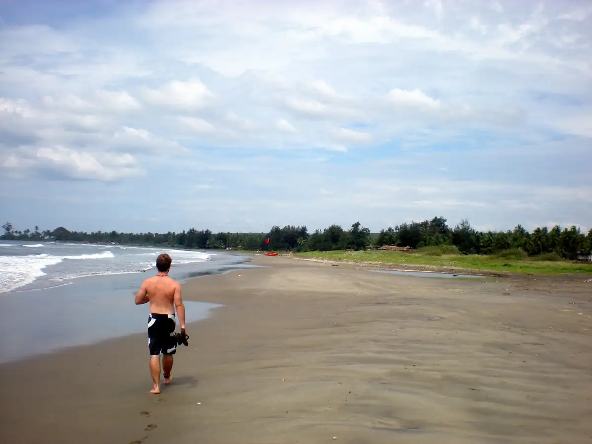 A tourist walks along an empty Goan beach Deserted Goa Beach